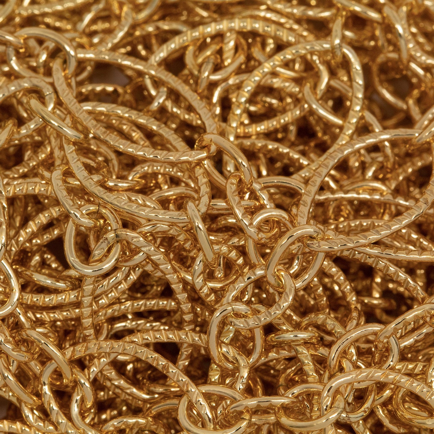 14kt Gold Filled One of 6.8mm Width by 11.0mm Length, Larger Corrugated Oval Link Followed by Three of 3.5mm Width by 4.7mm Length Smaller Links with Middle Smaller Link Being Corrugated, Long and Short Chain. Price per: 1 Foot.